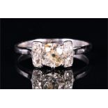 A platinum and diamond ring set with an old cut diamond of approximately 0.65 carats, flanked by two