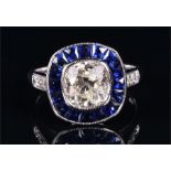 An 18ct white gold, diamond, and sapphire cluster ring in the Art Deco taste, collet set with an old