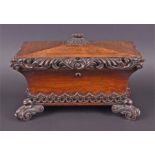 A 19th century rosewood tea caddy of sarcophagus form with carved acanthus leaf scroll decoration
