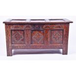 A 17th century carved oak three-panel coffer  with four demi lune motifs over three shallow relief