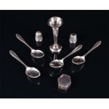 A small collection of silver items to include four coffee spoons, two silver thimbles, a miniature