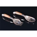 A Victorian serving spoon and fork pair with white metal mounts and worked Rhinoceros horn handles