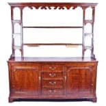 A large 18th century and later oak country dresser with two open plate shelves flanked by three