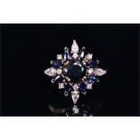 An 18ct white gold, diamond, and sapphire cluster ring centred with a round-cut sapphire