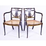 A pair of 19th century Sheraton style cane seated open armchairs with ebonised and gilt finished
