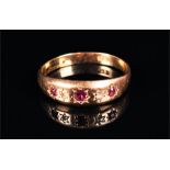 An 18ct yellow gold, diamond, and ruby gypsy ring set with three round cut rubies and two diamond