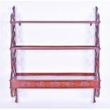 An early 20th century hardwood three-tier wall shelf in the oriental manner, the graduated shelves
