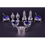 Two pairs of silver peppers together with two pairs of silver salts and a silver mustard, each