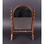 A late Victorian mahogany and inlaid toilet mirror of arched form, in a spindle turned frame on
