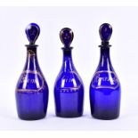 A set of three 19th century Bristol cobalt blue glass decanters and stoppers each with gilt