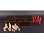 A late 19th century Chinese carved ivory chess set of red and white figural pieces, the king 11,3cm,