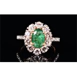 An 18ct yellow gold, diamond, and emerald cluster ring set with an oval-cut emerald of 1.50