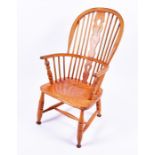 A late Victorian Windsor slat and spindle back armchair  in stained pine, raised on turned