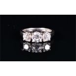 A platinum and diamond ring set with three round brilliant-cut diamonds of approximately 1.10 carats