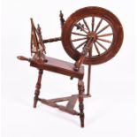 An early 20th century oak spinning wheel of typical design, 97 cm high x 89cm wide.