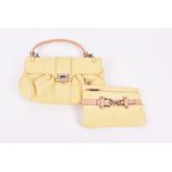 A Salvatore Ferragamo small handbag and matching purse in pale yellow leather, each with lined