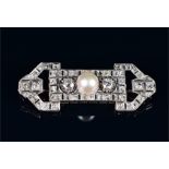 A white metal, diamond, and pearl brooch in the Art Deco style, centred with a white pearl,