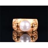 A yellow metal and synthetic pearl ring indistinct mark to exterior of shank, size N, 2 grams.