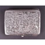 An Eastern white metal cigarette box the top deeply carved and engraved with pilgrim scenes of