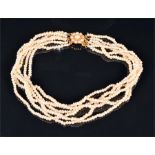 A natural saltwater seed pearl choker necklace composed of six strands, the pearl cluster clasp