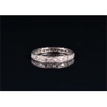 A diamond eternity ring set in unmarked white metal, set with twenty-five old round cut diamonds,