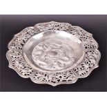 A Chinese sterling silver dish of stylisted form, the centre decorated with three flying dragons,