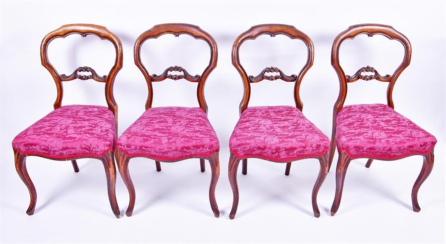 A set of four Victorian yoke back chairs  with red upholstered overstuffed seats on front cabriole