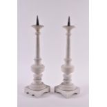 A large pair of turned and polished white marble candle stands with tapering cylindrical stems on