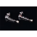 A pair of white metal and diamond earrings the mounts set with baguette and round-cut diamonds, each