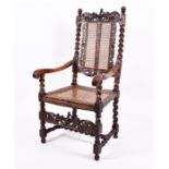 A Charles II style carved walnut armchair with intricately decorated top section depicting