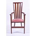 An Art Nouveau mahogany armchair the triple rail back with inlaid flowers, curved scrolling arms and