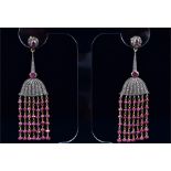 A pair of silver gilt and ruby drop earrings suspended with chains of faceted ruby beads, beneath