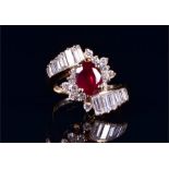 A 14ct yellow gold, diamond, and ruby crossover-style cocktail ring set with an oval cut ruby