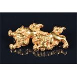A yellow metal Chinese 'Fu' (or Shi-Shi) dog brooch in the form of two Shi Shi dogs at play, stamped