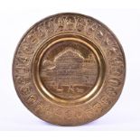 An early 20th century large Indian circular brass dish the central well with a chased view of the