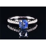 An 18ct white gold, diamond, and sapphire ring set with a cushion cut sapphire of approximately 1.38