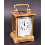 A small French carriage clock the white enamelled dial with black roman numerals, the gilded brass