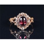 A garnet and diamond cluster ring the oval almandine cabochon garnet measuring 8 x 6mm, in a