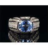 An 18ct white gold, diamond, and sapphire ring set with an oval-cut light blue sapphire of