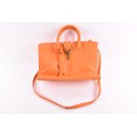 A Saint Laurent small Cabas Monogram handbag in vivid orange leather with gilt metal mounts and