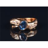 A yellow metal, synthetic spinel, and cubic zirconia ring set with a blue synthetic spinel, the