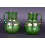 A pair of Loetz Crete Neptun glass jugs each with applied angular moulded green handles, the bowls