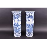 A pair of Chinese tall sleeve vases decorated in underglaze blue, with opposing reserves depicting