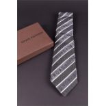 A Louis Vuitton grey and silver patterned silk tie boxed, with original bag, unused gift tag and