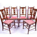 A set of six oak Arts & Crafts dining chairs with fixed upholstered seats with studded borders,
