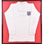 An England football replica shirt signed by Martin Peters the signature in black marker to the