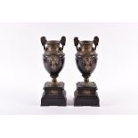 A pair of French Empire brass mounted black marble vases with intricate stylised Roman handles