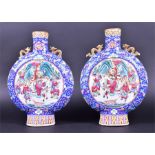 A pair of late 19th century or earlier Chinese porcelain moon flask vases each decorated with scenes