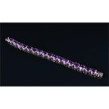 A silver and amethyst line bracelet set with seventeen oval cut amethysts, 17 cm.