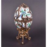 A late 20th century Russian silver gilt and enamel Easter egg decorated with enamel leaves and